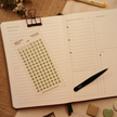Transparent fern green hexagon planner sticker sheet with 120 matte stickers displayed on an open weekly planner beside black tweezers and coordinating planner accessories. The sticker sheet reads 