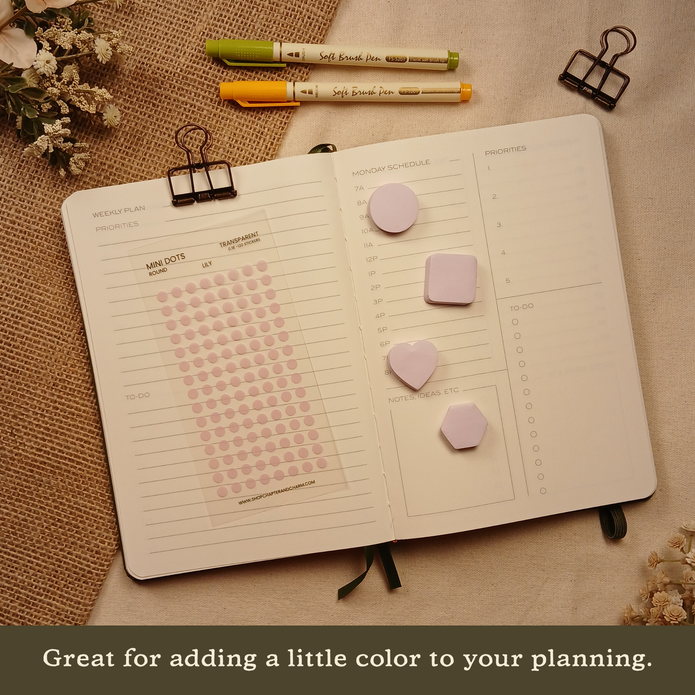 Lily light purple transparent matte round planner dot stickers displayed with coordinating sticky notes on an open planner. The image includes the text, 