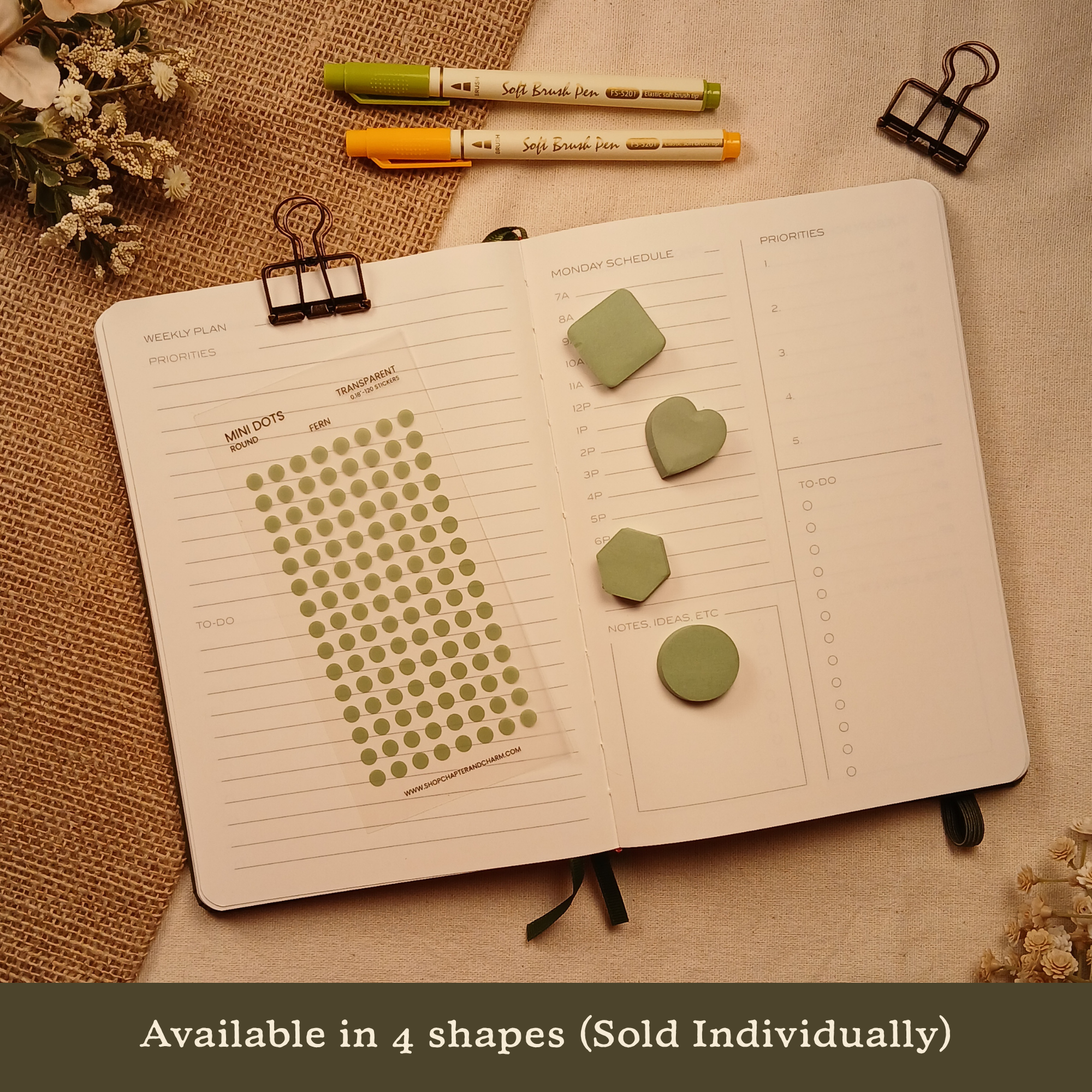 Fern green transparent matte round planner dot stickers displayed with coordinating heart, circle, square, and hexagon sticky notes on an open planner. The image includes the text, 