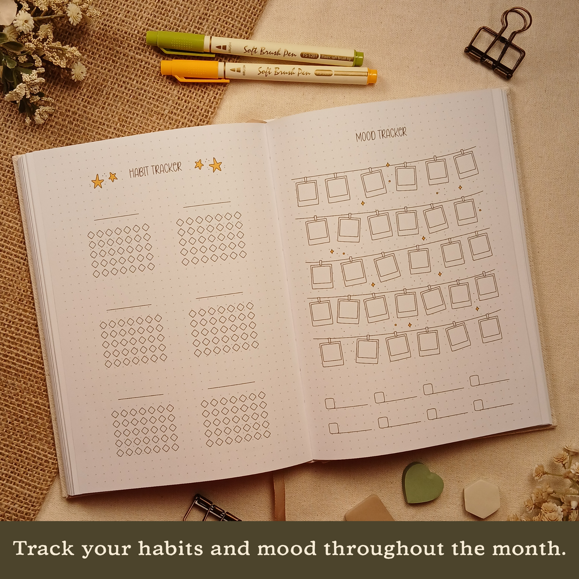 Open Booked Journal featuring monthly habit tracker and mood tracker pages with minimalist layouts and decorative accents. Text on image: 