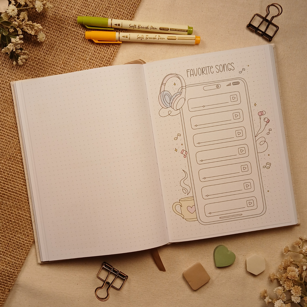 Open A5 dotted journal featuring a Favorite Songs stick-in page with soft earth-tone accents on the headphones, earbuds, and coffee cup. The music playlist design provides space to record favorite songs while adding a cozy, modern aesthetic to any journal spread.