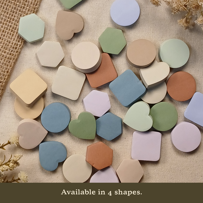 Assortment of pastel sticky notes in heart, circle, hexagon, and rounded square shapes displayed on a neutral linen background with the text 